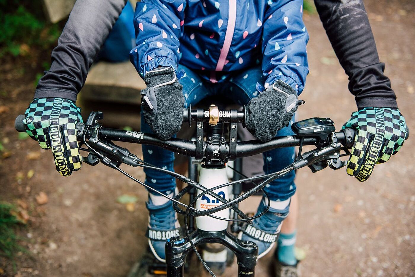 Kindersitz vorne von Shotgun Aus der Lenkerperspektive Kind sitzt vorne im Kindersitz von Shotgun, erwachsende Person steuert, man sieht die behandschuhten Hände am Lenker